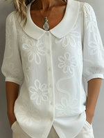 Camicia vintage con colletto Peter Pan e ricami floreali.