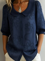 Camicia vintage con colletto Peter Pan e ricami floreali.
