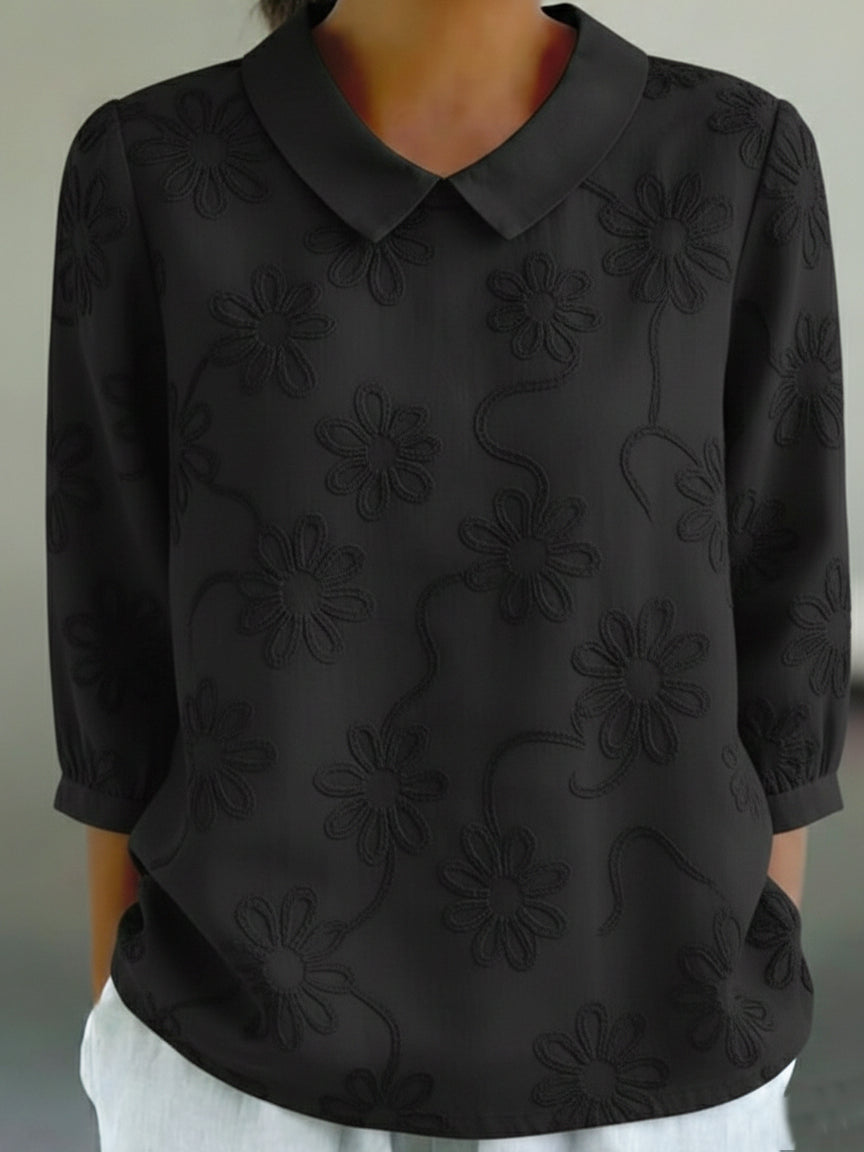 Camicia romantica con colletto Peter Pan e ricami floreali.