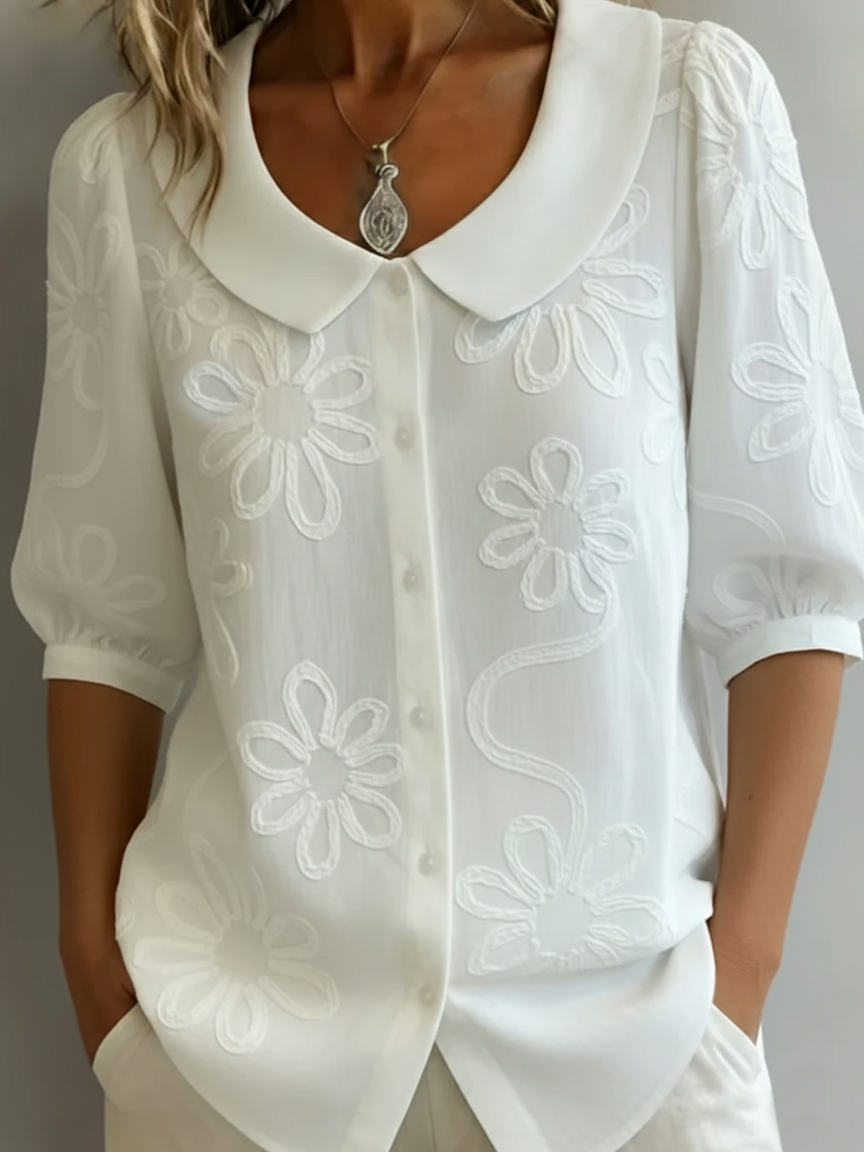 Camicia vintage con colletto Peter Pan e ricami floreali.