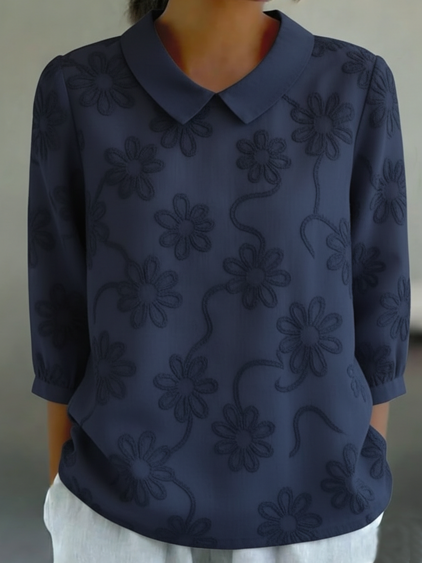 Camicia romantica con colletto Peter Pan e ricami floreali.